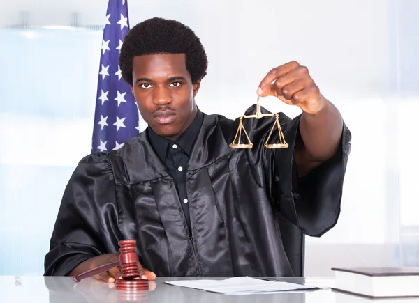 Male Judge Holding Gavel And Scale In Courtroom — Stock Photo, Image