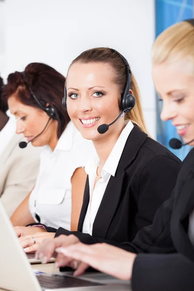 Schöne junge Frau spricht auf dem Headset — Stockfoto