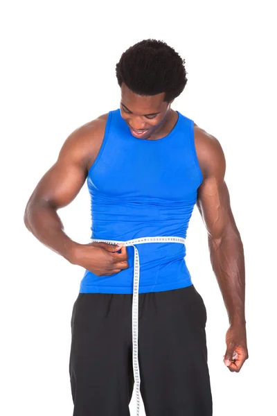 Fisiculturista com uma fita métrica em torno de sua cintura — Fotografia de Stock