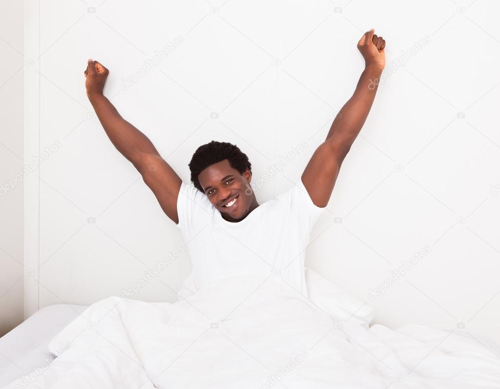 Young Man Waking Up At Bedroom