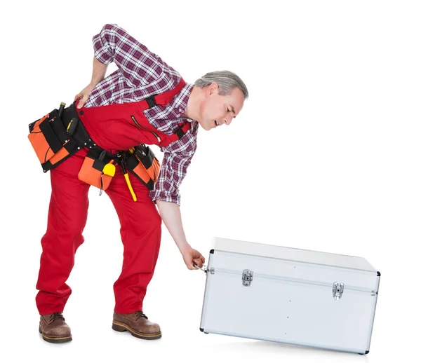 Uomo tecnico con mal di schiena sollevamento scatola di metallo — Foto Stock