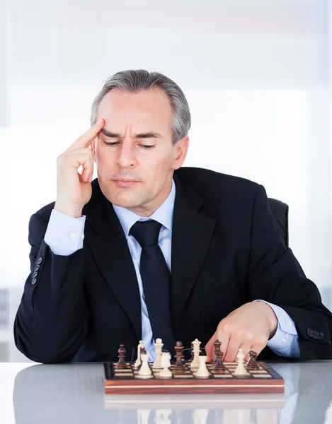 Reifer Geschäftsmann spielt Schach — Stockfoto