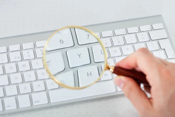 Mirando la tecla del teclado a través de lupa —  Fotos de Stock