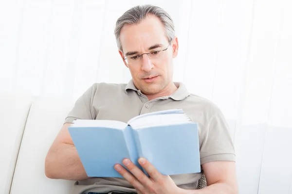 Dojrzały mężczyzna czytający książkę — Zdjęcie stockowe
