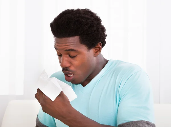 Young Man Blowing His Nose In A Tissue — Stock Photo, Image
