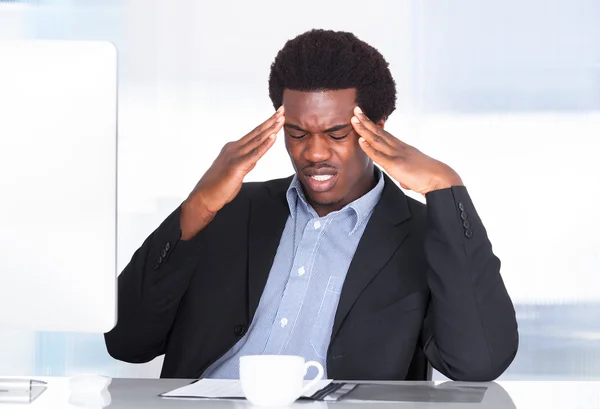 Бизнесмен, страдающий от головной боли — стоковое фото