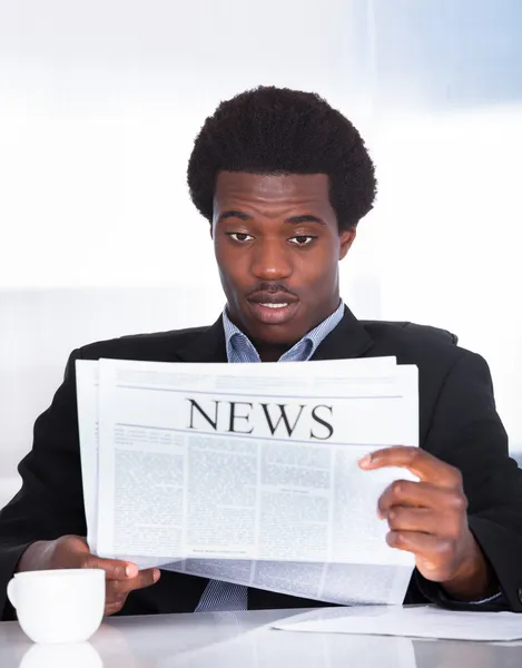 Geschockter Geschäftsmann liest Zeitung — Stockfoto