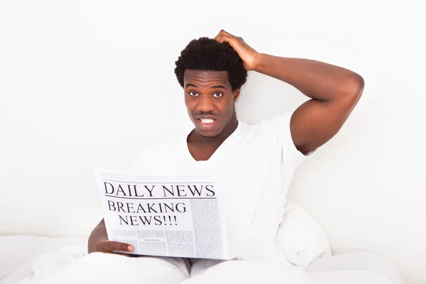 Worried Young African Man With Newspaper — Stock Photo, Image