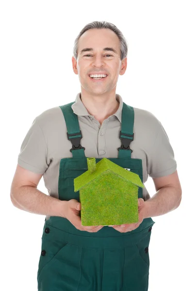 Happy man holding house covered with grass — Stock Photo, Image