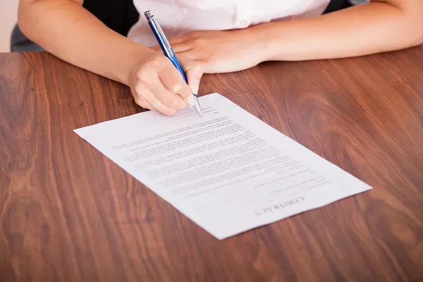Kvinna underteckna kontrakt papper — Stockfoto