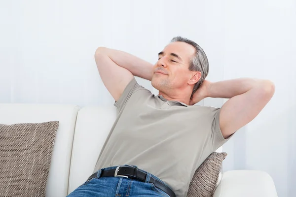 Szczęśliwy człowiek dojrzały relaksujący na kanapie — Zdjęcie stockowe
