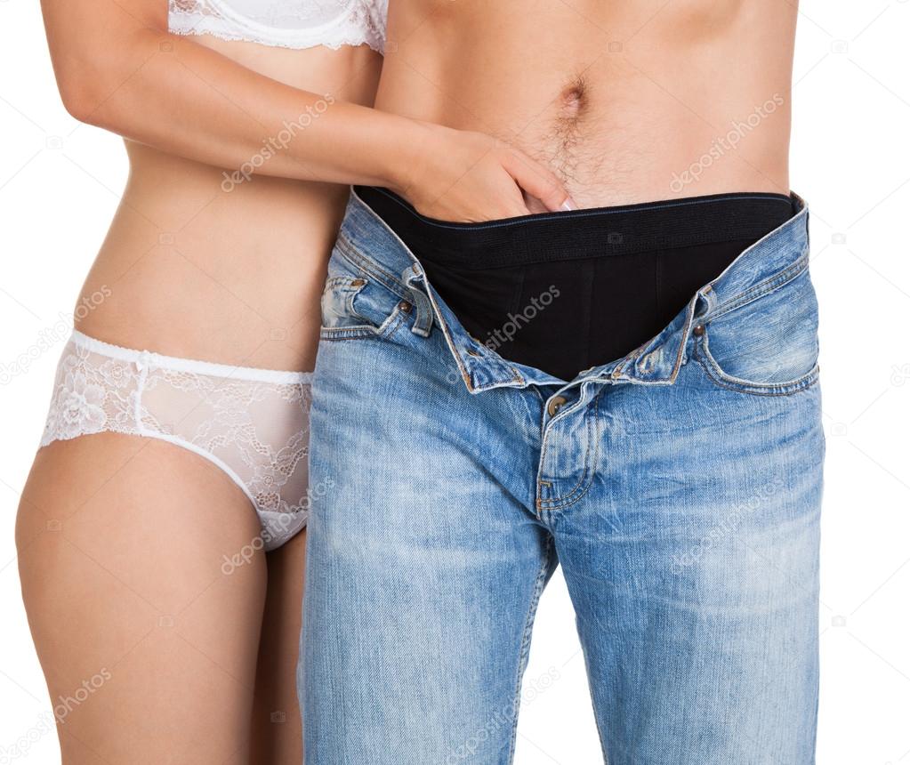 Woman inserting her hands in man's jeans