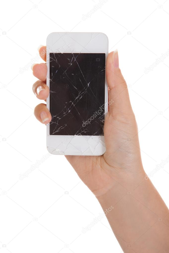 Hand holding smartphone with cracked screen