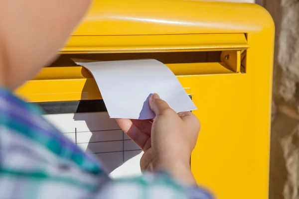 Frau steckt Umschlag in Briefkasten — Stockfoto