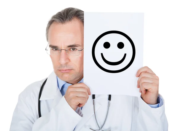 Doktor drží papír s usmívající se obličej — Stock fotografie