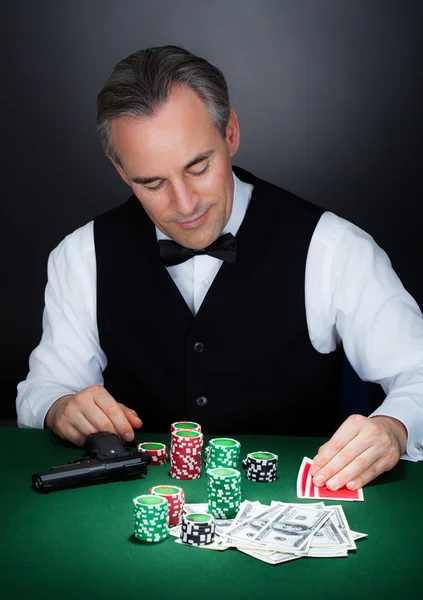 Ritratto di un croupier che guarda le carte da gioco — Foto Stock