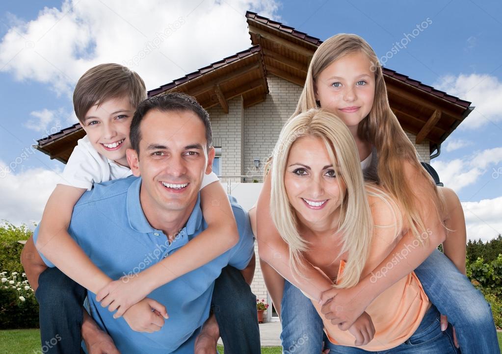 Happy Family In Front Of House