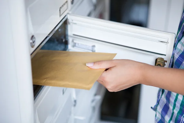 Frauenhand zieht Kuvert aus Briefkasten — Stockfoto