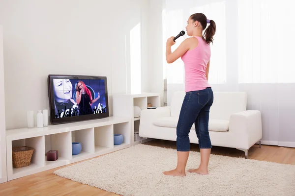 Jovem mulher cantando karaoke — Fotografia de Stock