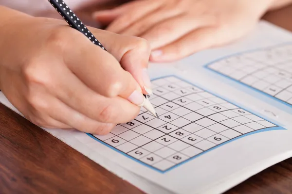 Vrouw oplossen van sudoku — Stockfoto