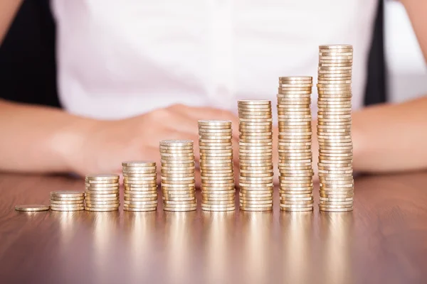 Mujer mano apilamiento moneda de oro — Foto de Stock