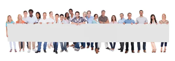 Group of business people with a blank banner — Stock Photo, Image