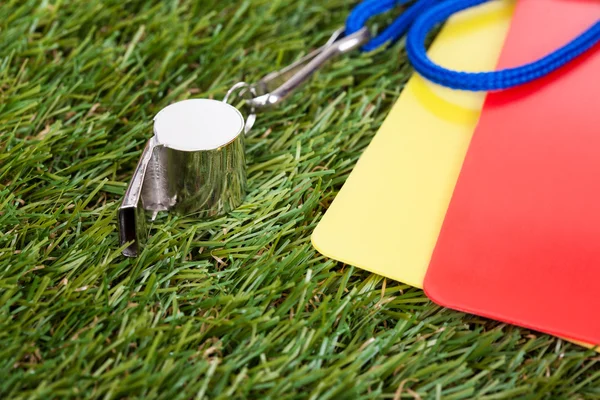 Silbato con tarjeta roja y amarilla en el campo — Foto de Stock