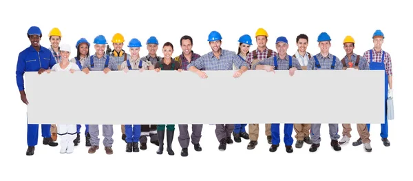 Groep van werknemers in de bouw met plakkaat — Stockfoto