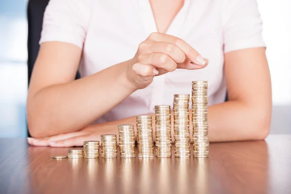 Mujer mano apilamiento moneda de oro —  Fotos de Stock