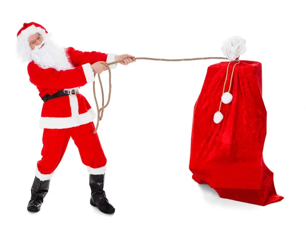 Santa pulling gifts sack — Stock Photo, Image