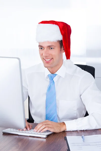 Podnikatel nosit klobouk santa — Stock fotografie