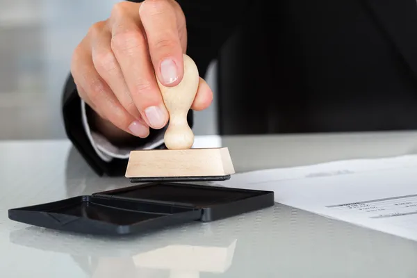 Business man hand met rubber stempel — Stockfoto