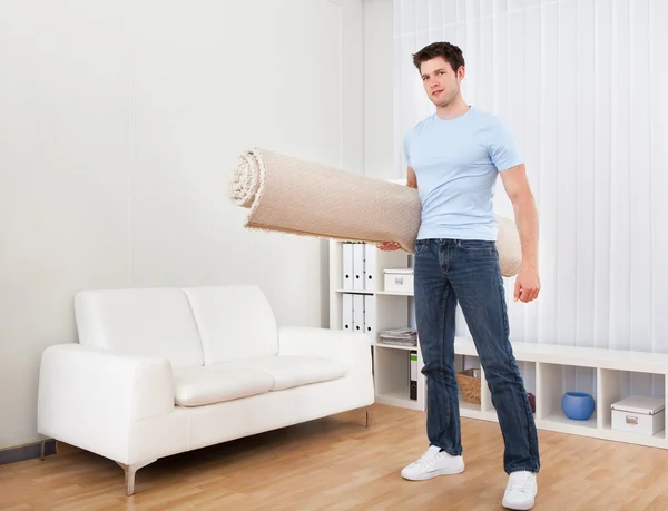 Young Man Holding Carpet — Stock Photo, Image