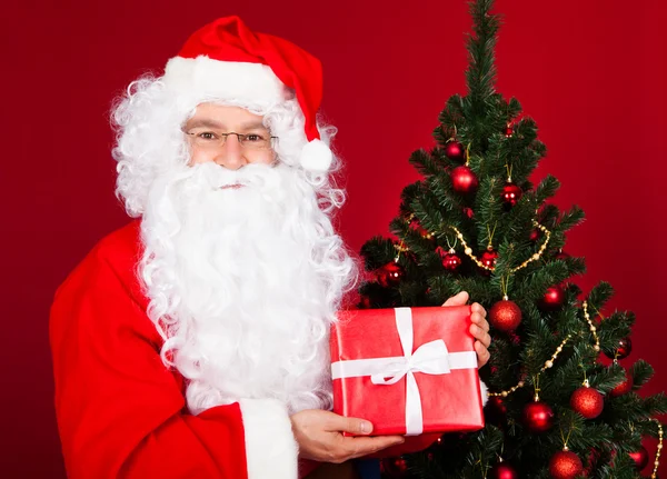 Santa holding hediye — Stok fotoğraf