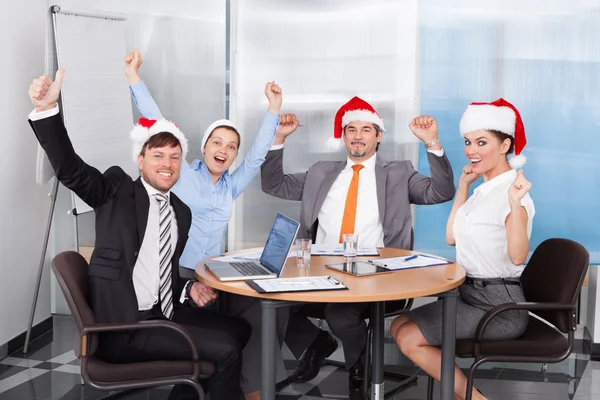 Kollegen mit Weihnachtsmütze feiern — Stockfoto