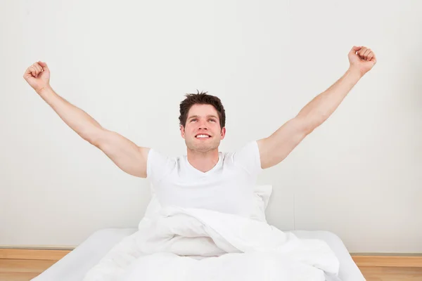 Man With Arm Raised On Bed — Stock Photo, Image