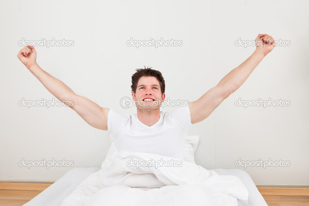Man With Arm Raised On Bed