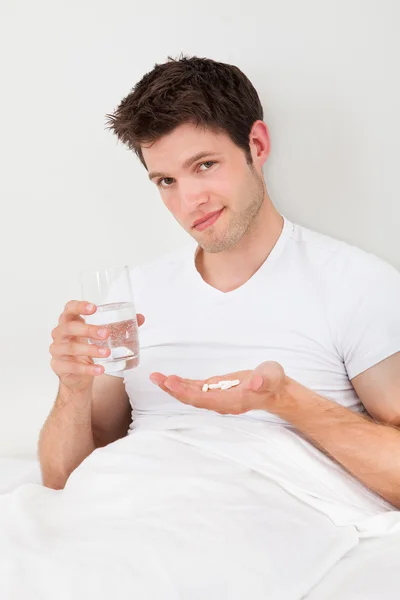 Man bedrijf geneeskunde en glas — Stockfoto