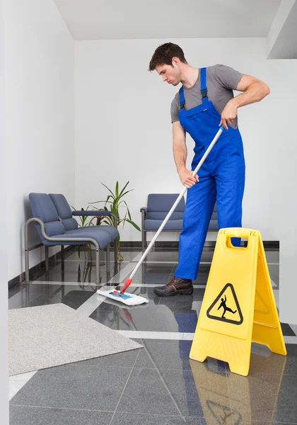 El hombre limpiando el piso — Foto de Stock