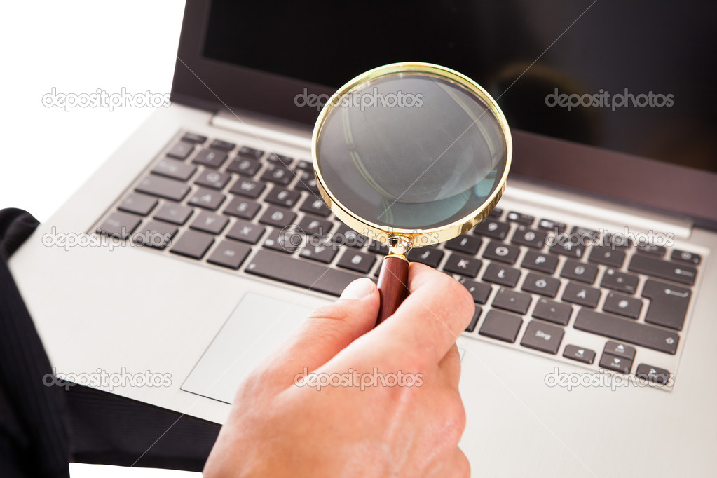 Man Holding Laptop And Magnifying Glass