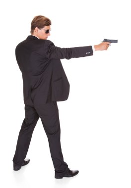 erkek gizli ajan silahıyla hedefleyen