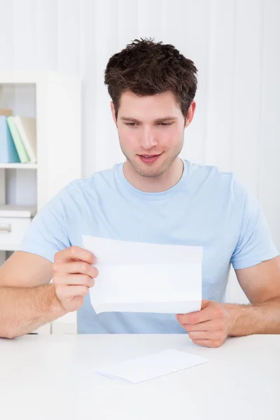 Homem feliz olhando para o papel — Fotografia de Stock