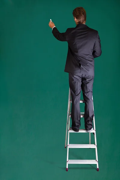 Podnikatel, stojící na žebříku — Stock fotografie
