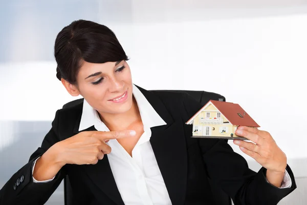 Businesswoman Pointing Towards House Model — Stock Photo, Image