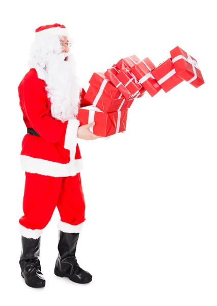 Porträt des Weihnachtsmannes, der einen Stapel Geschenke in der Hand hält — Stockfoto