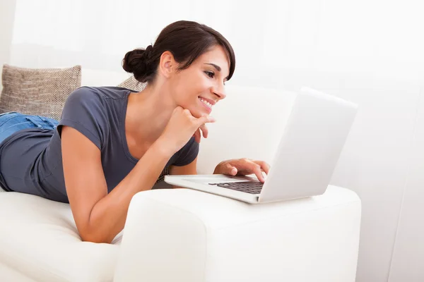 Kvinna med laptop på soffa — Stockfoto