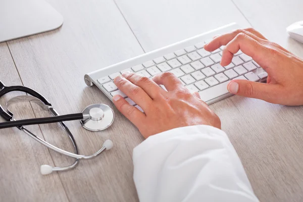 Docteur mâle tapant sur le clavier de l'ordinateur — Photo