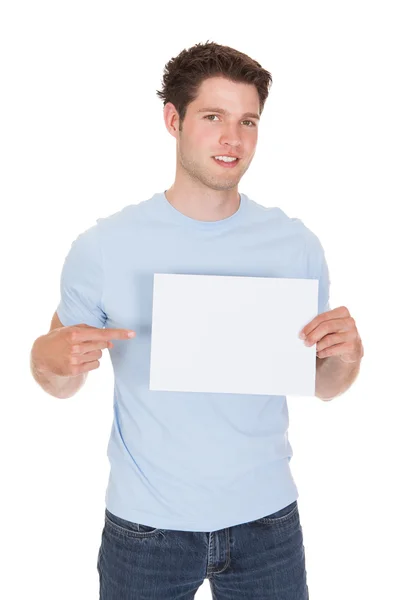 Mutlu genç adam boş afişini holding — Stok fotoğraf