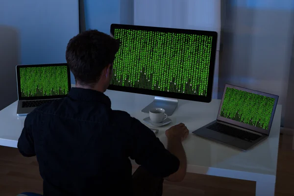 Hombre sentado con el ordenador portátil y la computadora — Foto de Stock