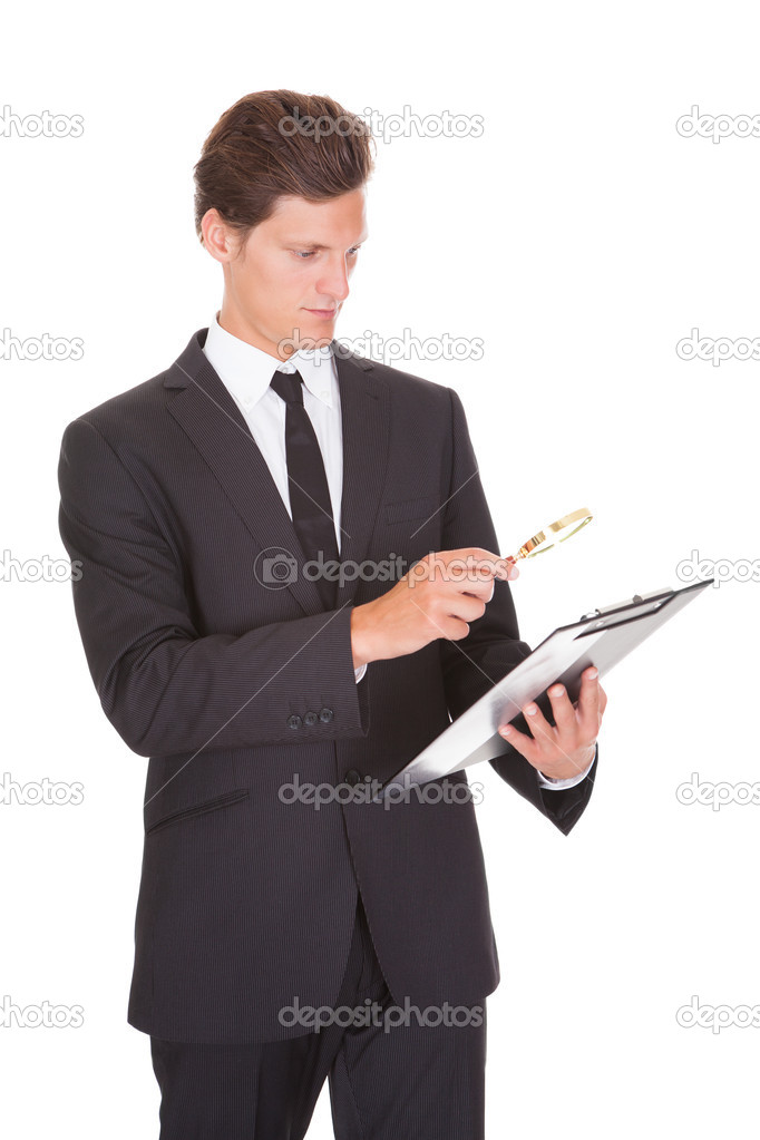 Man Looking Through Magnifying Glass On Clipboard